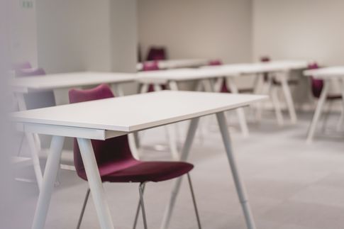 Vita skrivbord med röda stolar kontor