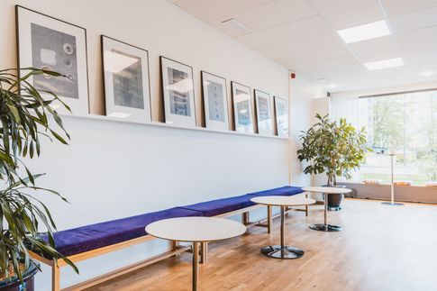 Tavelvägg vita bord och blå väggbänk