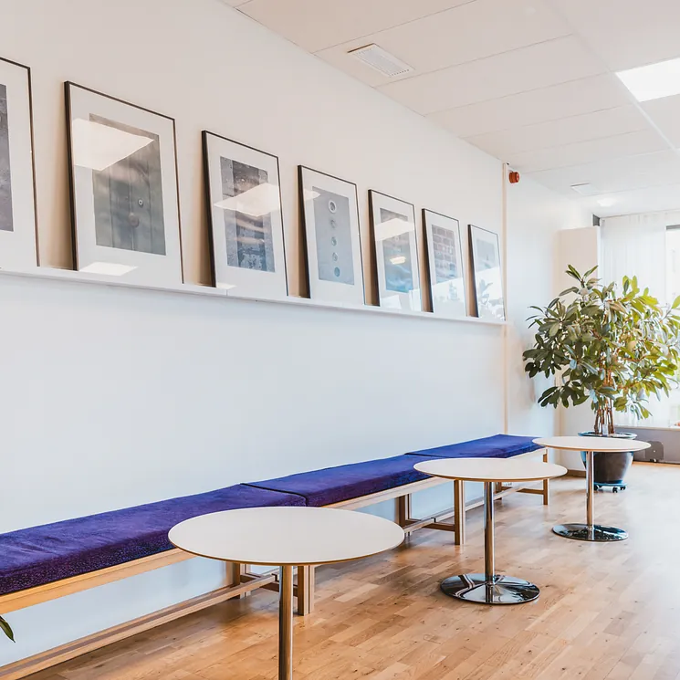 Tavelvägg vita bord och blå väggbänk